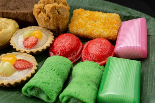 Colorful array of Indonesian pastries displayed on a banana leaf, showcasing traditional desserts.