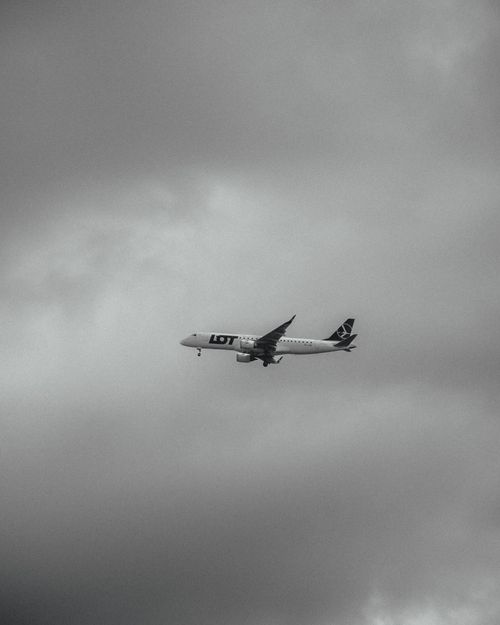 Free A LOT aircraft captured mid-flight against a dramatic cloudy backdrop. Stock Photo