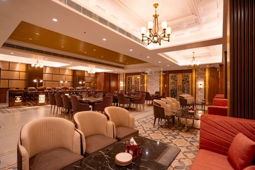 Free A luxurious restaurant interior featuring chandeliers, modern furniture, and warm lighting. Stock Photo