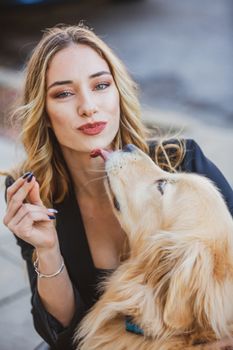 一名女子在户外与她的金毛猎犬愉快互动