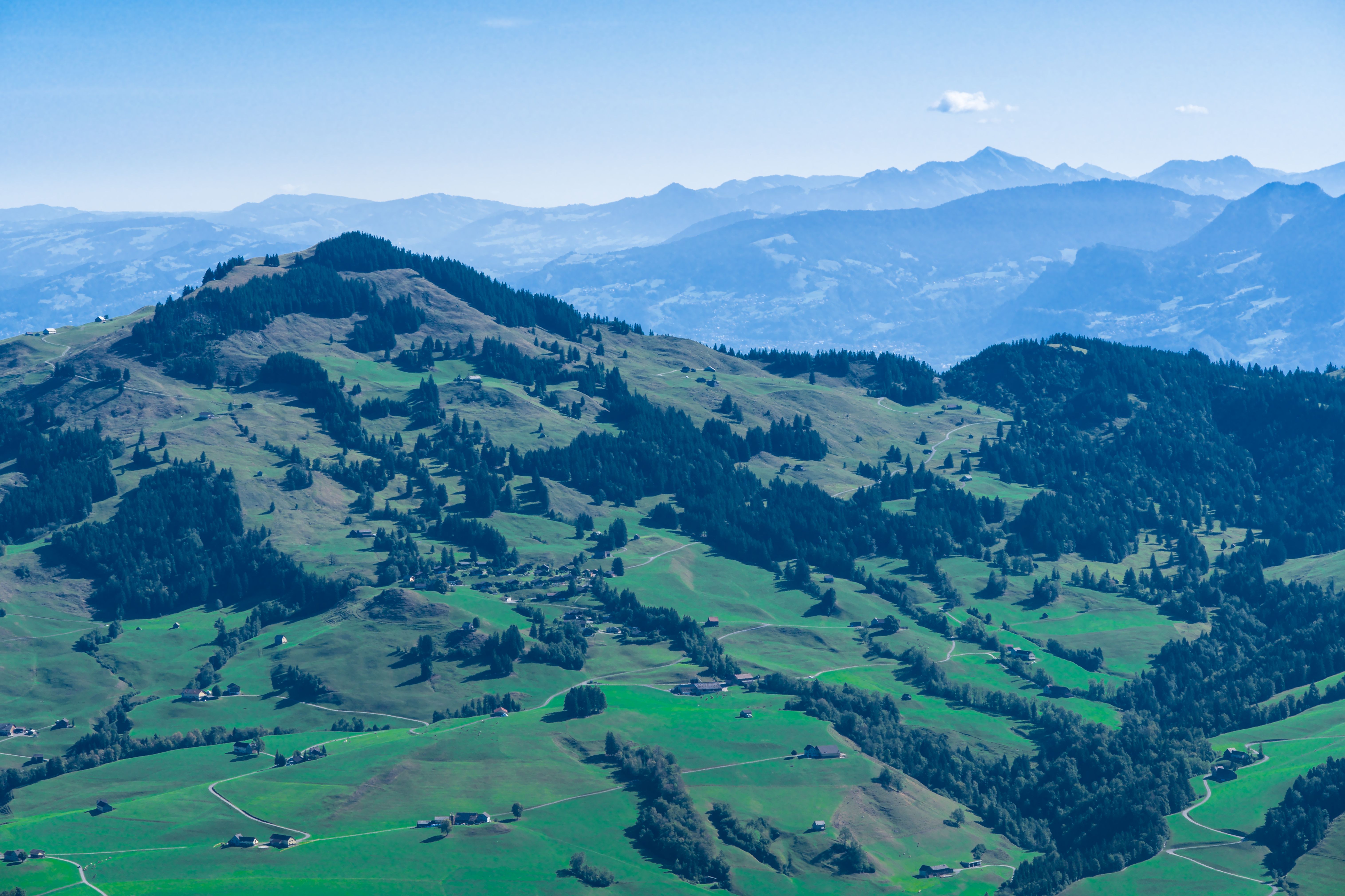 Breathtaking aerial view of the lush landscapes and rolling hills of the Swiss Alps.