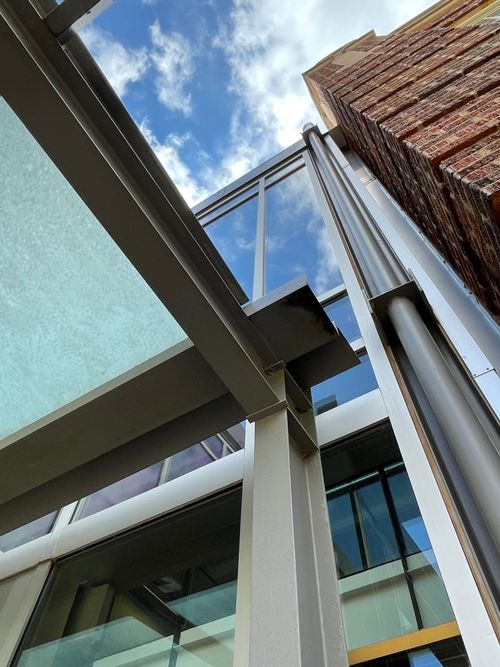 Free Artistic perspective of modern building structures against a blue sky. Stock Photo
