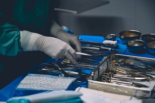 Free Surgeon organizing surgical instruments on a sterile table before operation. Stock Photo