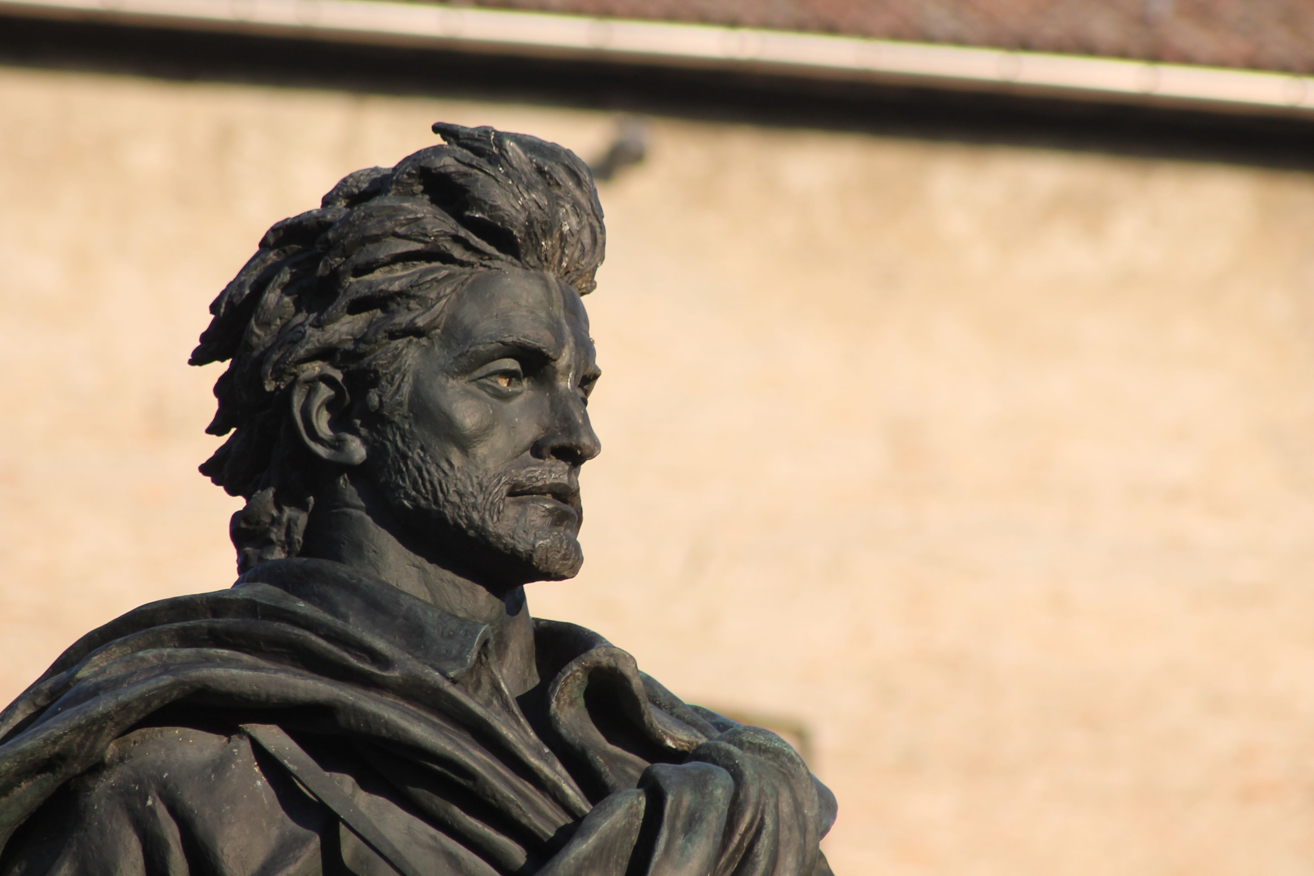 Close-up of a bronze statue of a historical figure in Parma, Italy. Captures artistic details and expression.