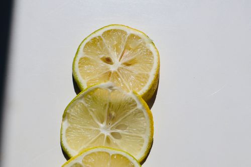 Free Top view of fresh lemon slices arranged on a bright white surface. Stock Photo