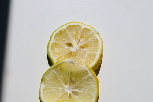 Free A sharp close-up image of fresh lemon slices with a shadow on a white background. Stock Photo