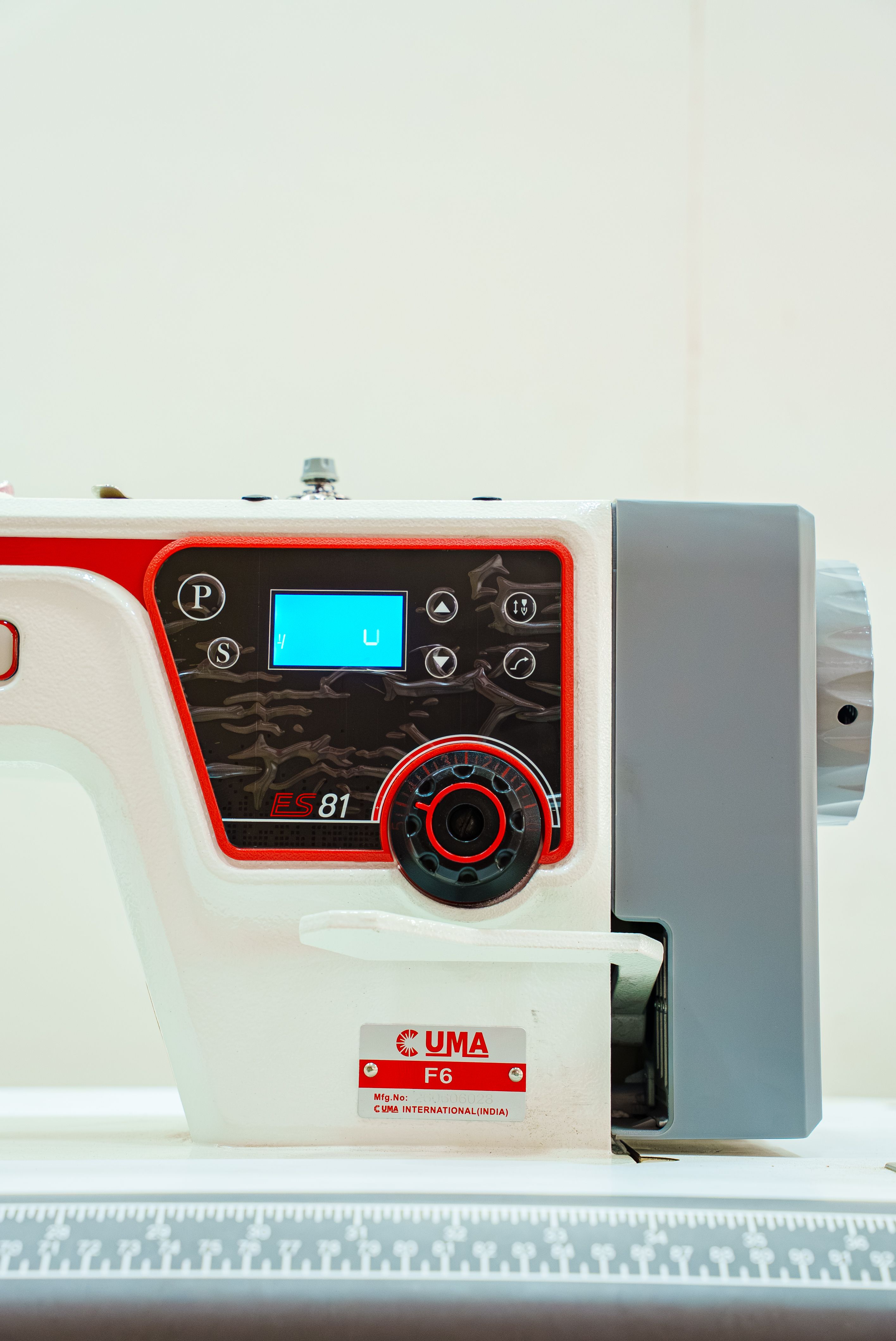 Detailed view of an industrial sewing machine control panel with digital display.