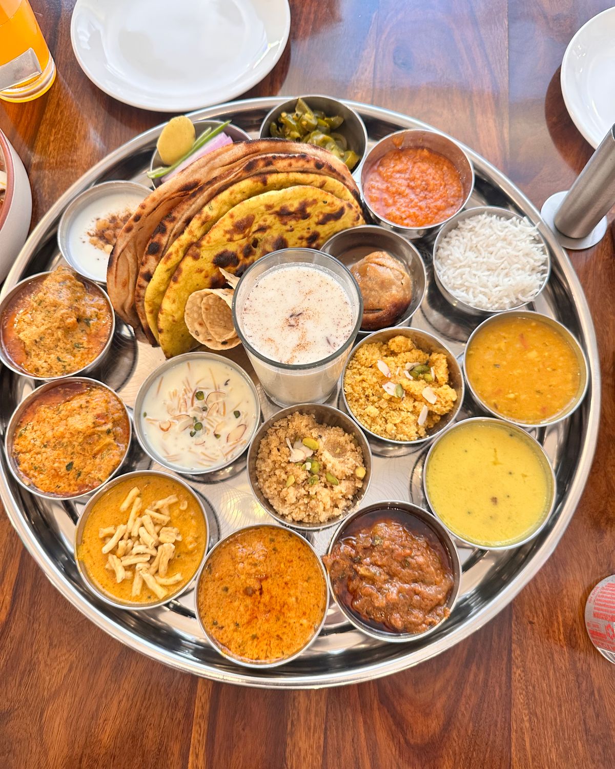A vibrant Indian thali with various dishes including chapati, curry, and rice, beautifully arranged on a tray.