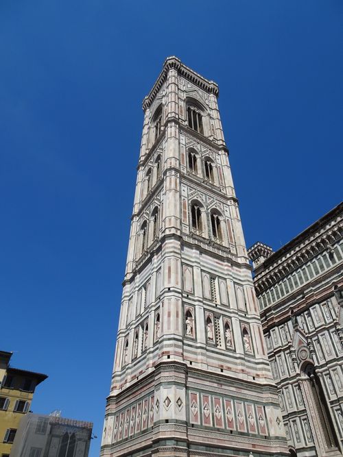 Free A majestic view of Giotto's Campanile Tower against a clear blue sky in Florence, Italy. Stock Photo