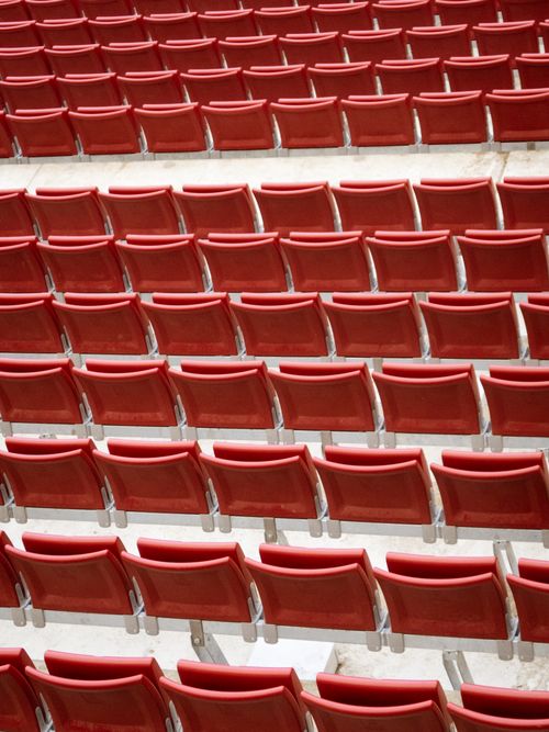 Free Empty red stadium seats arranged in a neat, repeating pattern. Stock Photo