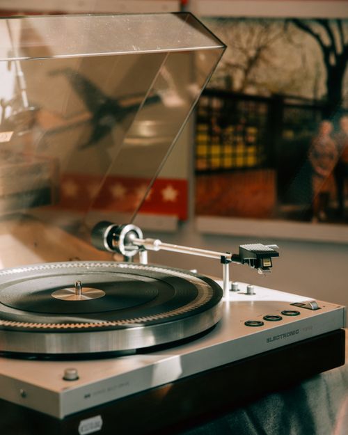 Free A classic turntable set up in a warmly lit room, evoking nostalgia with a touch of elegance. Stock Photo