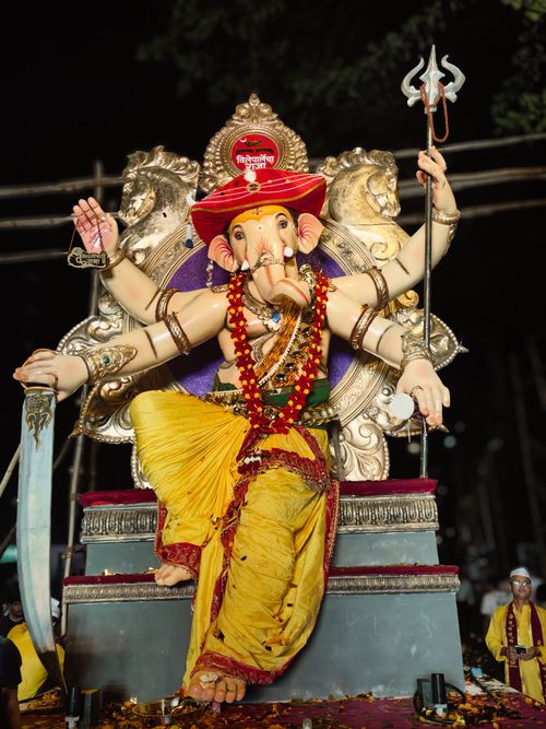 Free Colorful Ganesh idol during a night celebration in Mumbai, India. Captures the vibrancy and culture of the festival. Stock Photo