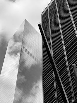单色视角下的摩天大楼高耸入云，建筑线条与倒影引人注目
