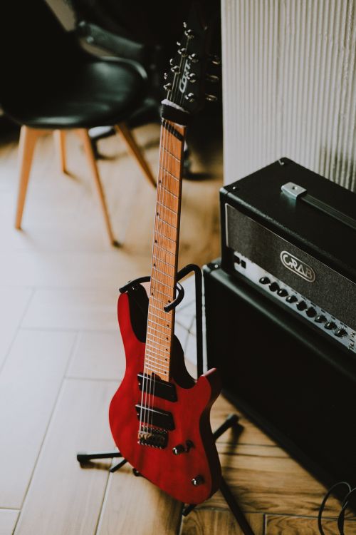 Free Red electric guitar and amplifier setup in a modern indoor setting. Ideal for music or musician-themed content. Stock Photo