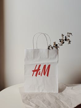 A white shopping bag with eucalyptus adds a natural touch in a minimalist setting.