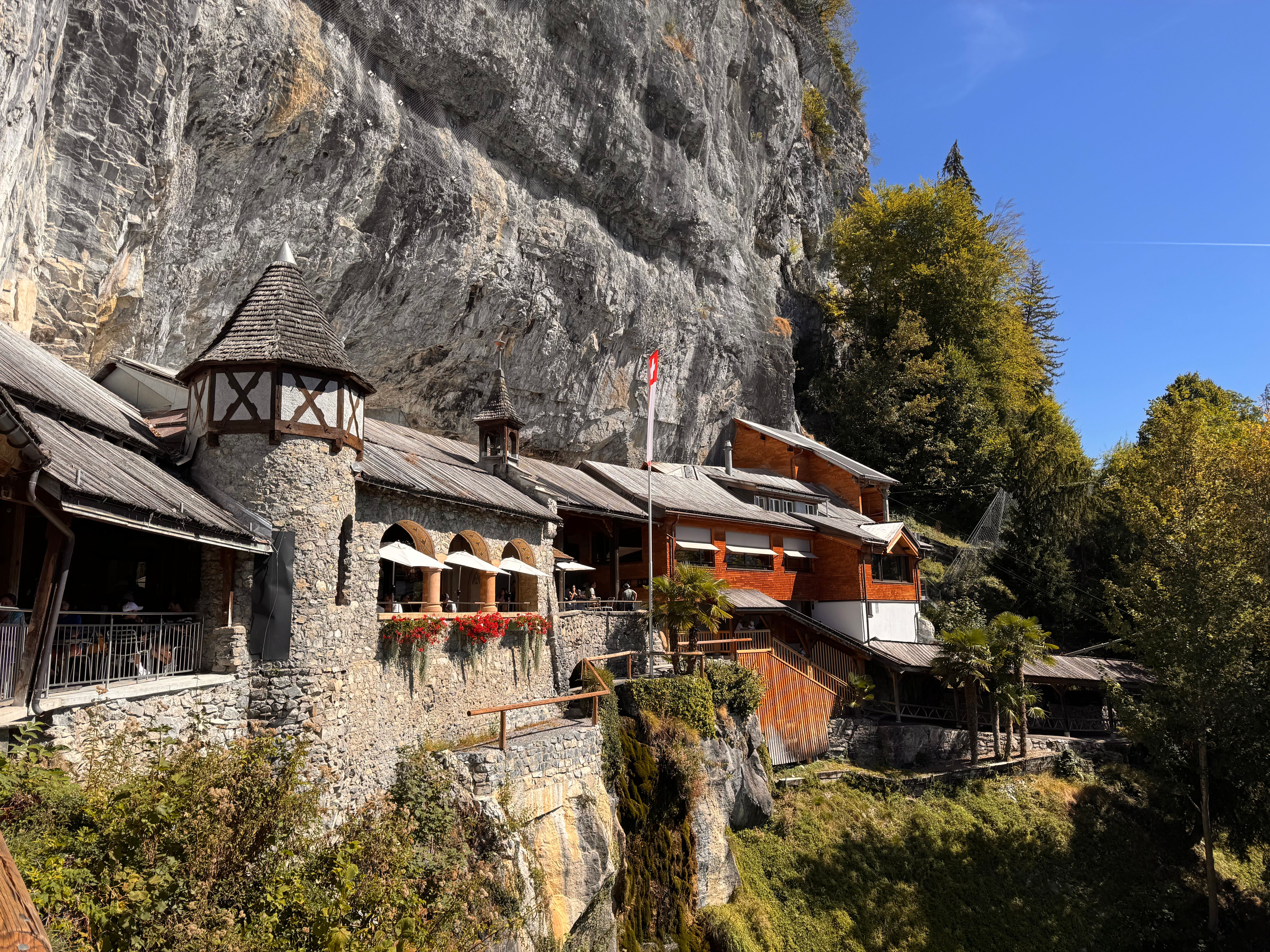 Rustic wooden chalet nestled against a scenic Swiss cliff, offering a picturesque view.