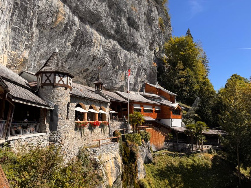 Rustic wooden chalet nestled against a scenic Swiss cliff, offering a picturesque view.