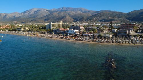 Free Stunning aerial shot of Malia, Greece showing the beach and surrounding mountains. Stock Photo