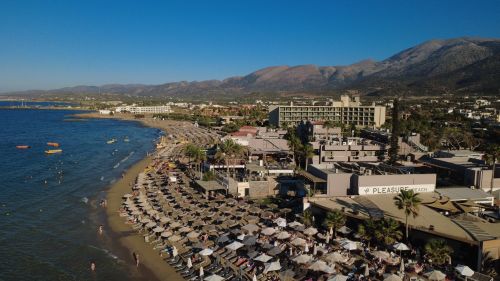 Free Stunning aerial shot of Malia's beachfront with resorts and mountains in the background. Stock Photo