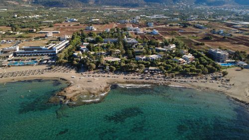 Free Stunning aerial shot of a beachfront resort in Malia, Greece, showcasing the pristine coastline and picturesque landscape. Stock Photo
