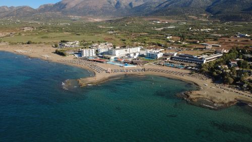 Free Stunning aerial shot of beachfront hotels in Malia, Crete, with clear blue waters and sandy beaches. Stock Photo
