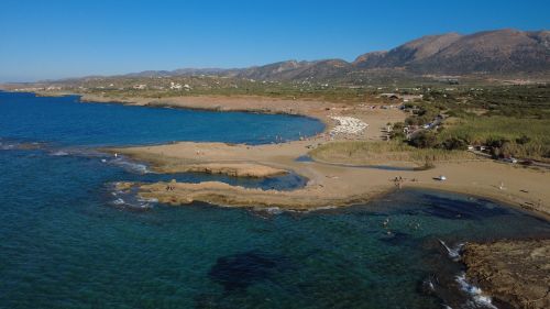 Free Aerial shot of Malia Beach in Greece showcasing clear waters and scenic coastline. Stock Photo