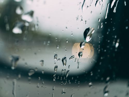 Free Abstract image showcasing raindrops on a window with blurred bokeh lights. Stock Photo