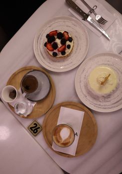 Top view of desserts and coffee on a cafe table, perfect for food lovers.