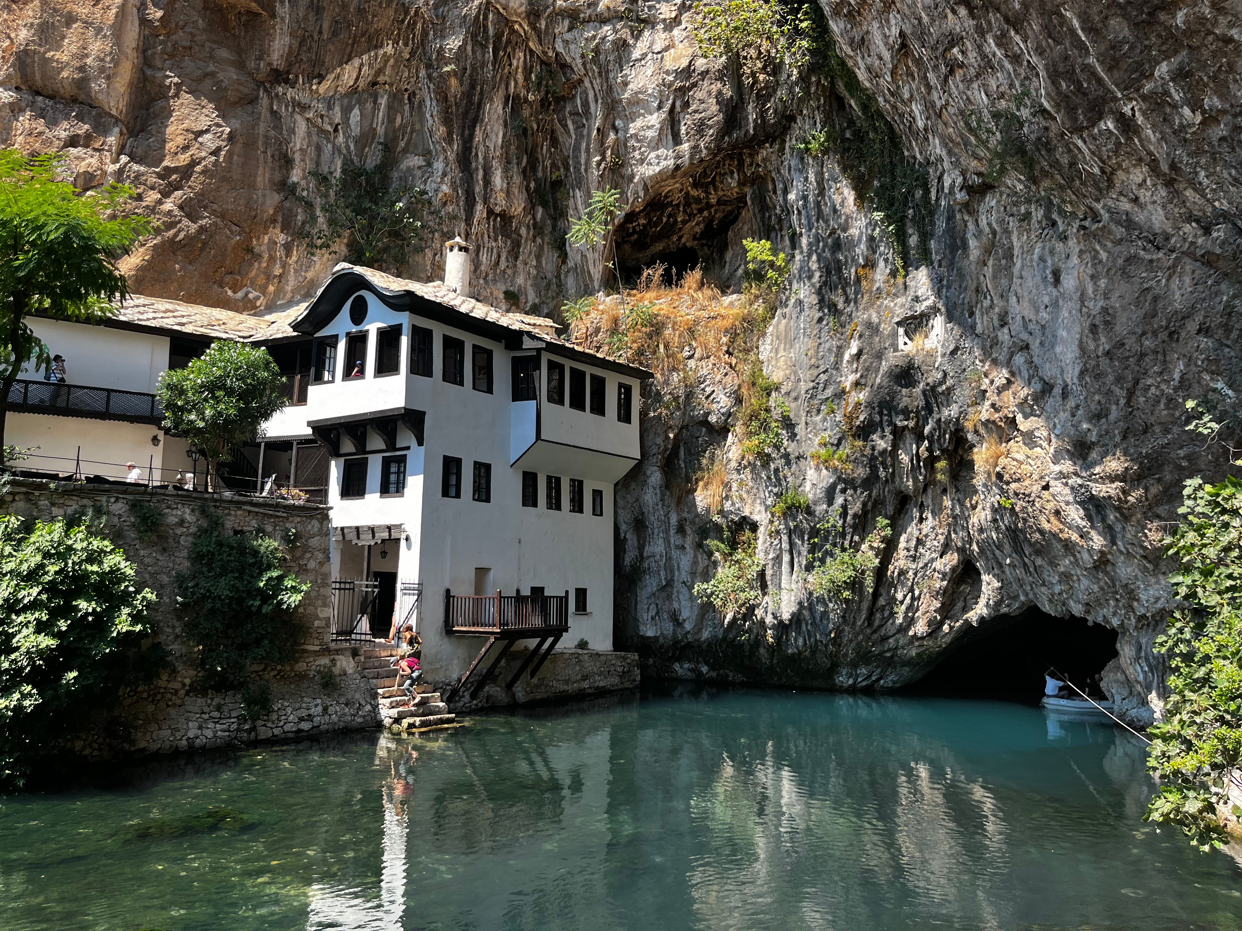 Beautiful view of Blagaj Tekija monastery by the serene river, nestled in a rocky cliffside.