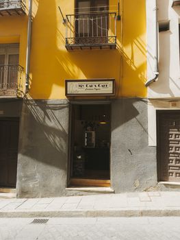 Explore the inviting entrance of My Cat's Cafe with its vibrant yellow walls in historic Cuenca.