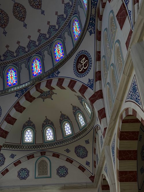 Free Breathtaking interior view of a mosque dome with intricate designs and colorful stained glass windows. Stock Photo