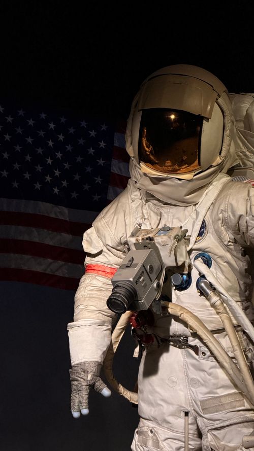 Free Detailed image of an astronaut in a space suit with an American flag backdrop, capturing space exploration. Stock Photo