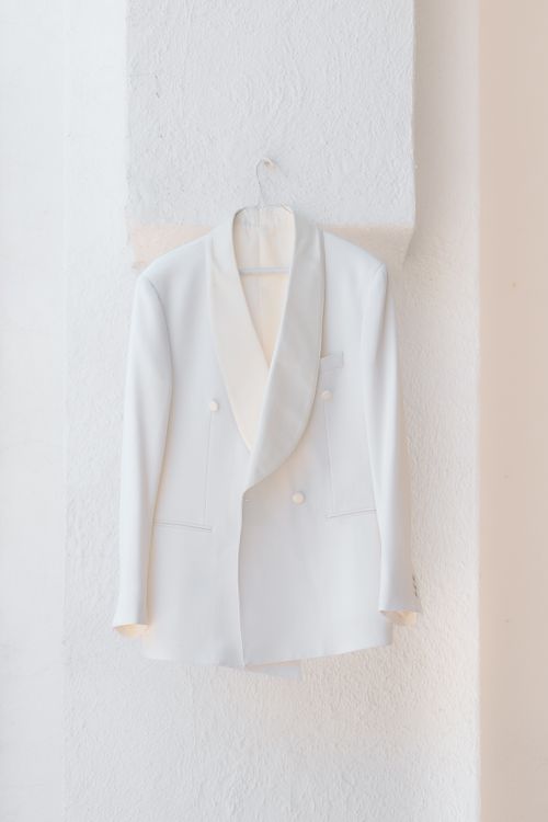 Free Stylish white double-breasted suit jacket on hanger, perfect for formal occasions. Stock Photo