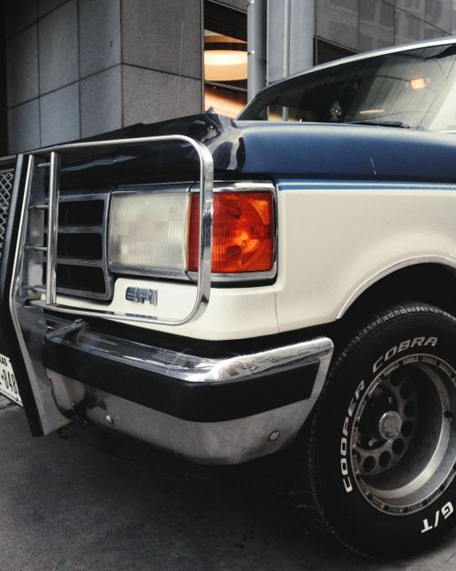 Free Close-up of a classic truck parked in downtown Houston, showcasing the headlights and bumper. Stock Photo