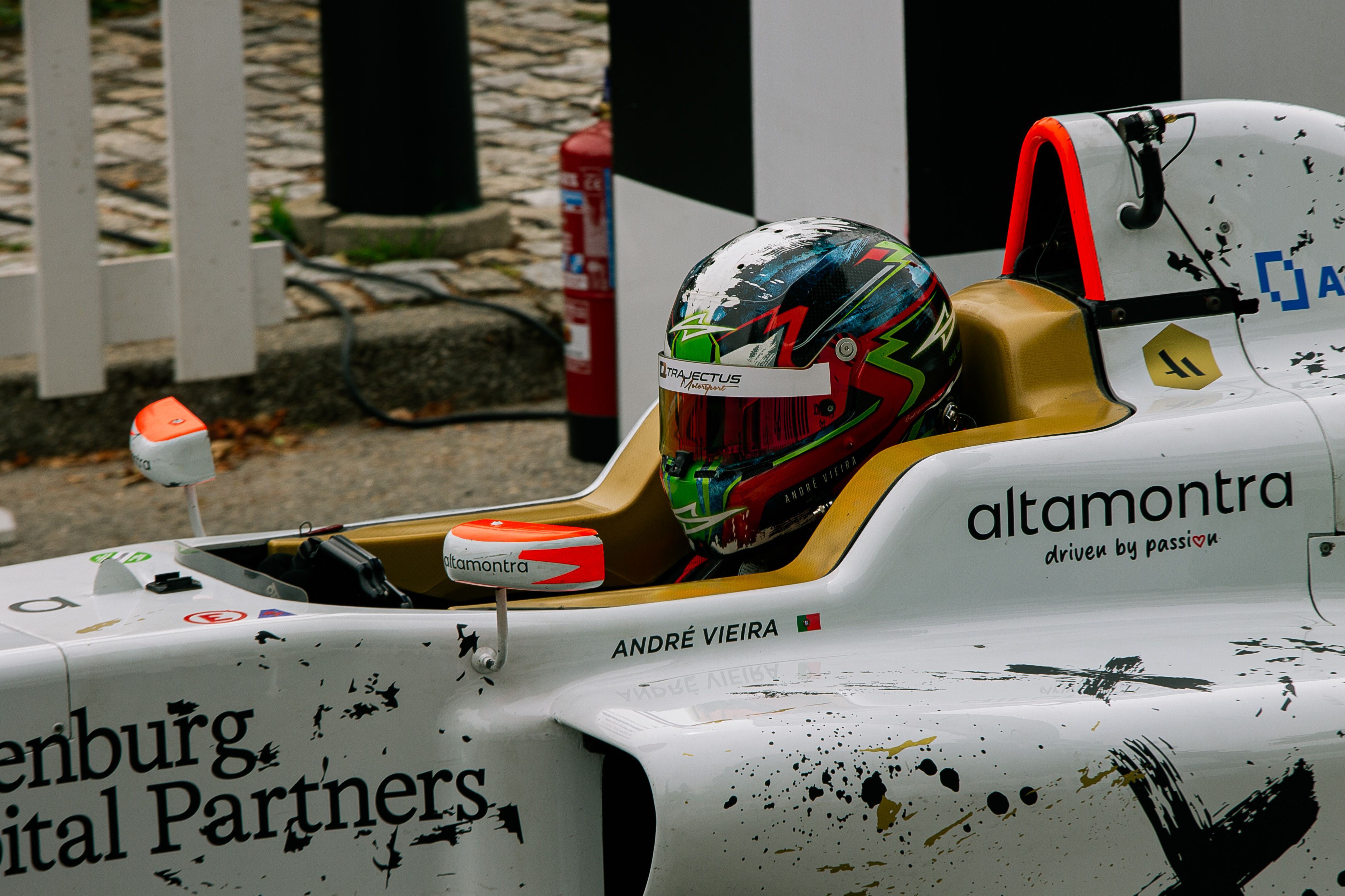 Close-up of a Formula One driver in a racing car on the track.