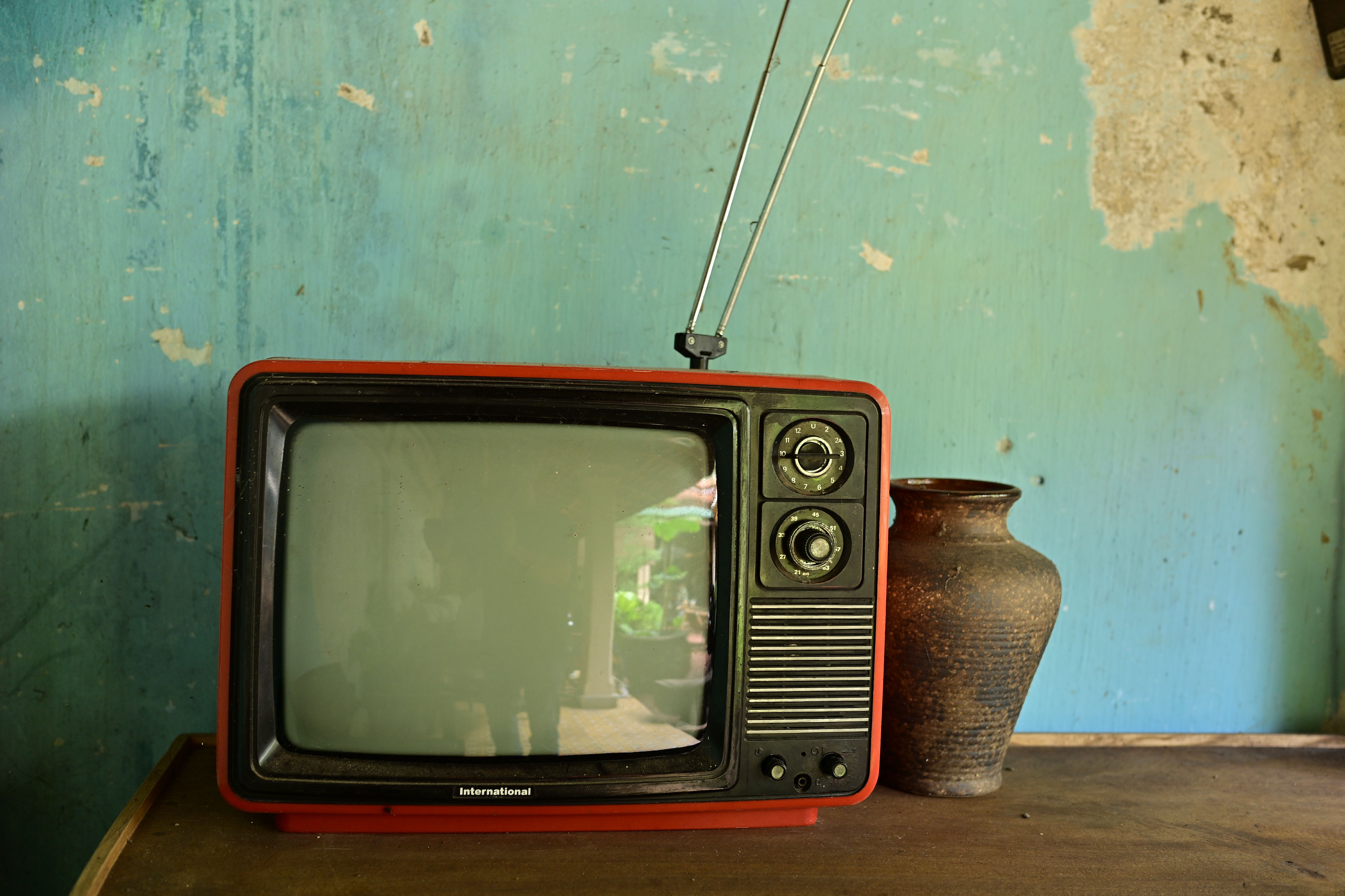 a living-room television showing a World Cup fixture while a laptop displays regional broadcast information