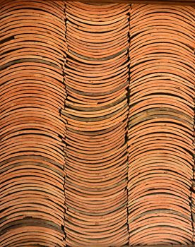Background of neatly stacked terracotta roof tiles, showcasing texture and pattern.