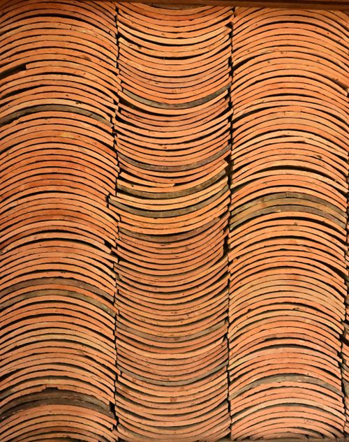Free Background of neatly stacked terracotta roof tiles, showcasing texture and pattern. Stock Photo