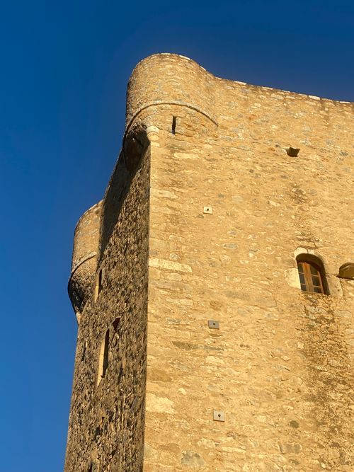 Free A stunning medieval tower in Mani Peninsula, Greece, basking in golden sunset light. Stock Photo