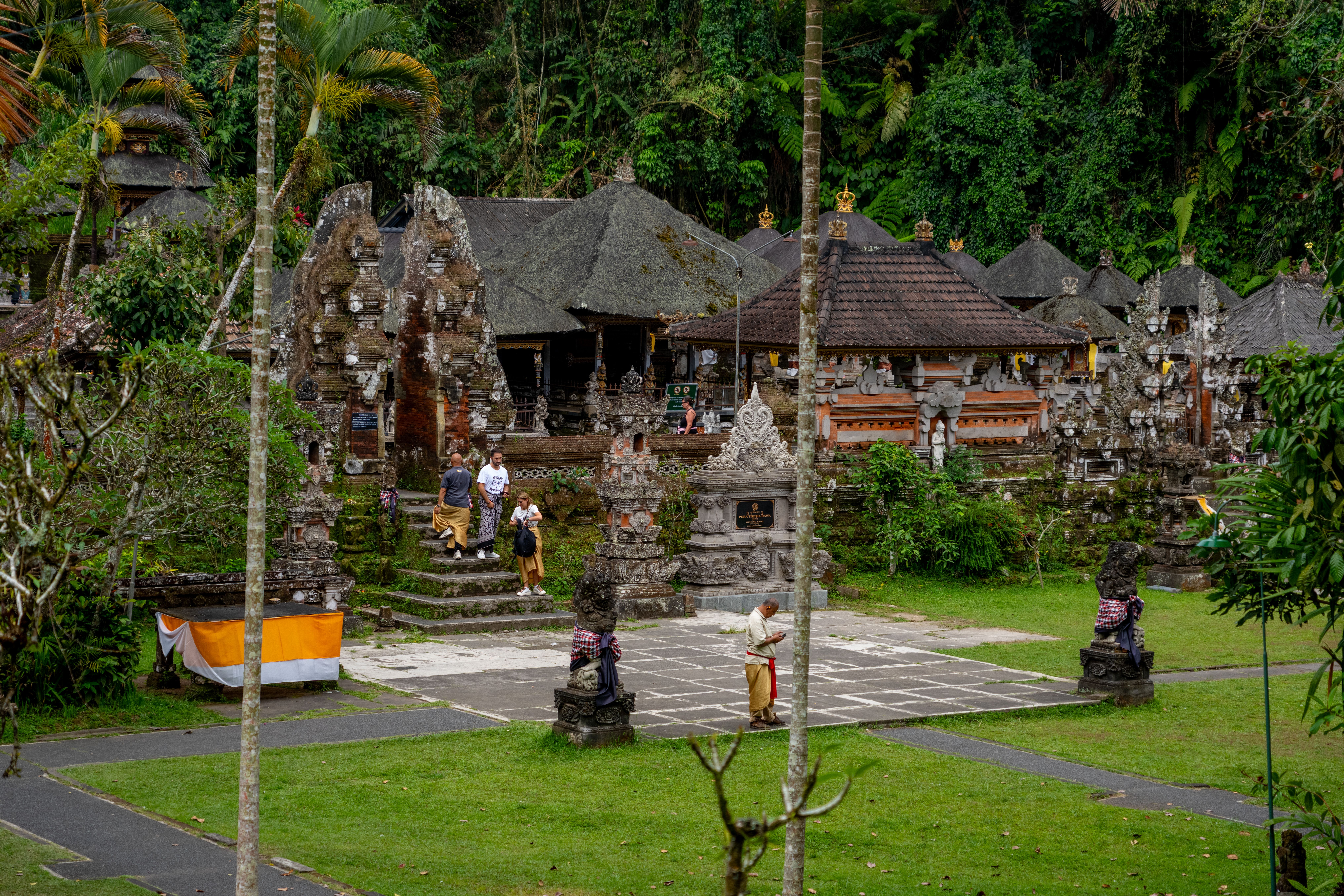 Sân làng Bali trong nghi lễ truyền thống, người dân đứng quanh khu vực tổ chức với trang phục địa phương