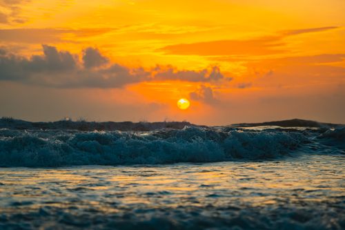 Free A stunning sunset view over the ocean with vibrant orange and blue hues, highlighting the beauty of nature. Stock Photo
