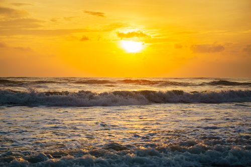 Free A breathtaking golden sunset over rolling ocean waves, creating a serene and vibrant scene. Stock Photo