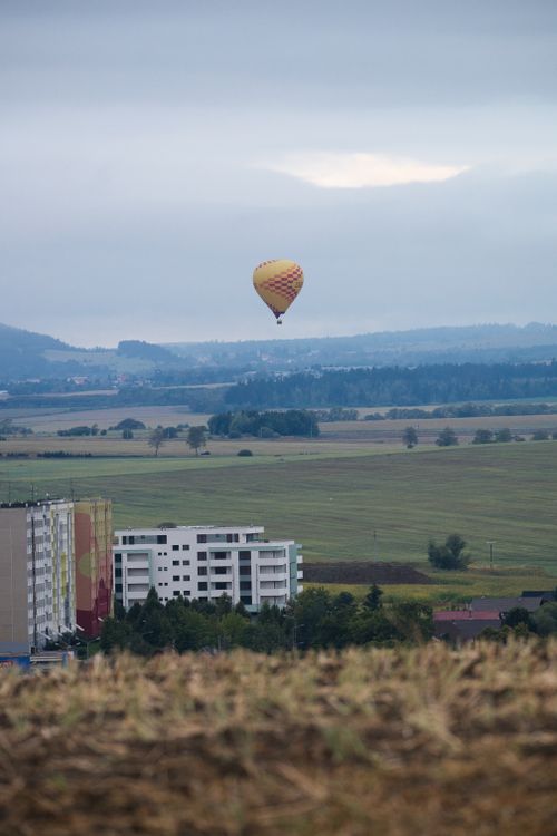 Free Hot air balloon floating over scenic Poprad landscape on a cloudy day, capturing Slovakia's serene beauty. Stock Photo