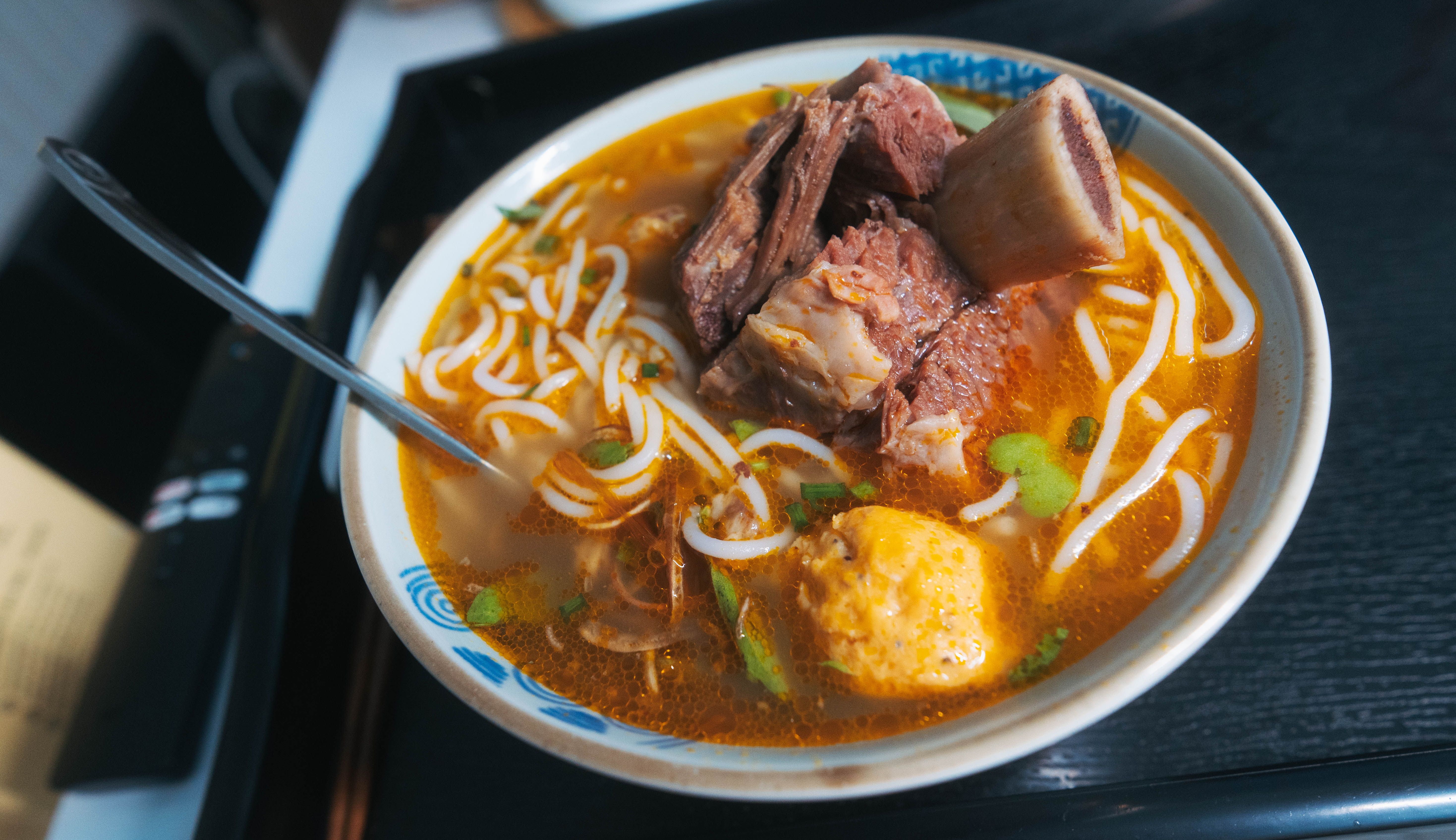 Delicie-se com uma tigela saborosa de pho vietnamita tradicional, coberto com carne e macarrão.