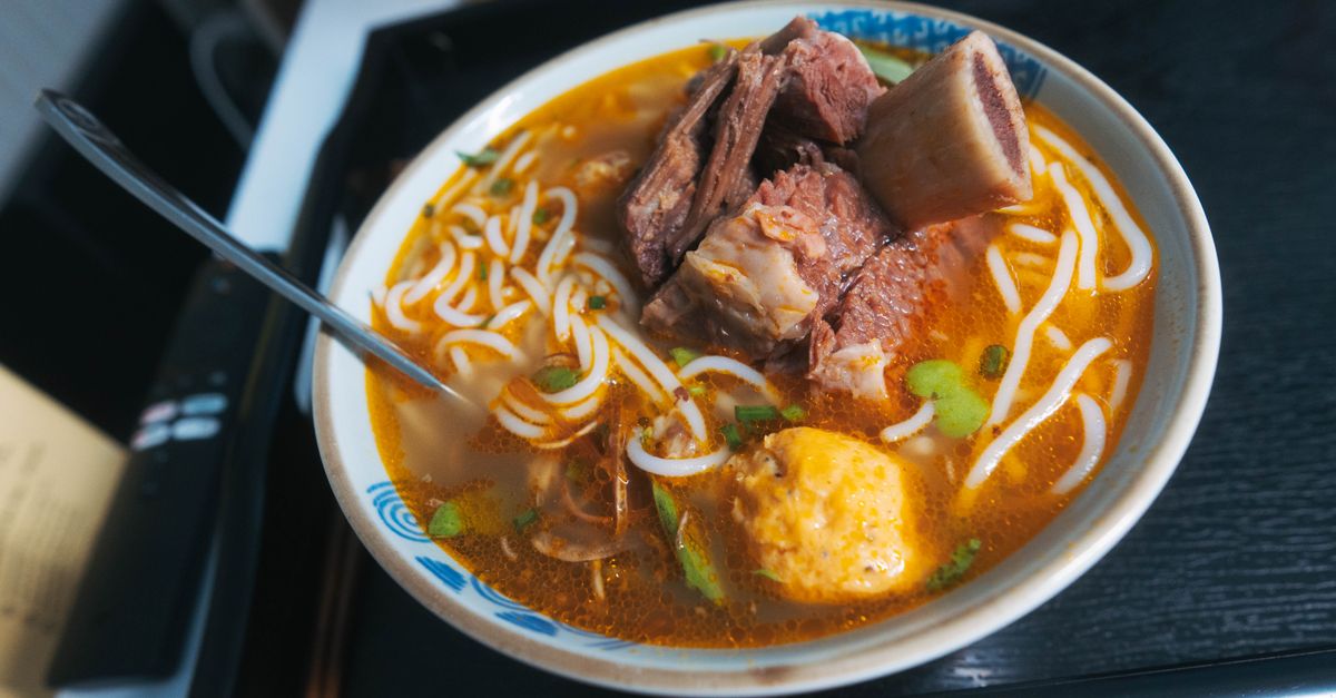 Delicie-se com uma tigela saborosa de pho vietnamita tradicional, coberto com carne e macarrão.