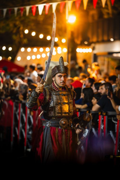 Free A knight in traditional armor participates in a lively night parade during a medieval festival. Stock Photo