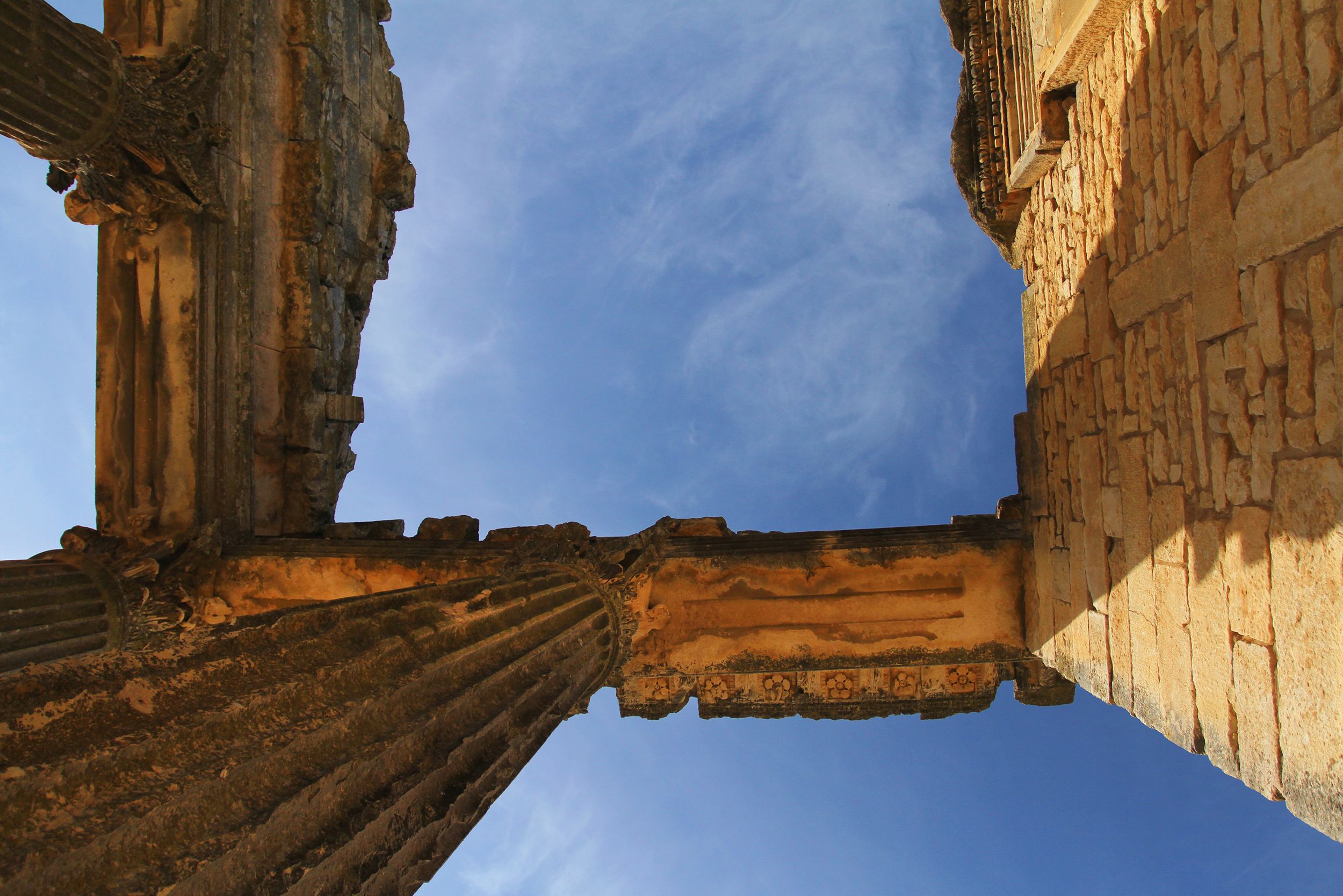 View of ancient Roman ruins in Téboursouk, Tunisia against a clear blue sky.