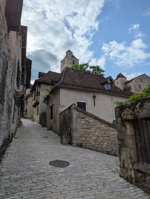 Free Quaint cobblestone street in Saint-Cirq-Lapopie, featuring historical architecture and a serene atmosphere. Stock Photo