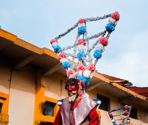 Free A person in a vibrant festival costume with striking headgear outdoors. Stock Photo