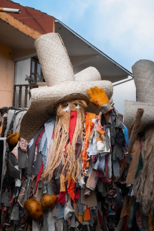 Free Colorful Mexican festival costume with mask, straw hat, and vibrant textiles in an outdoor setting. Stock Photo